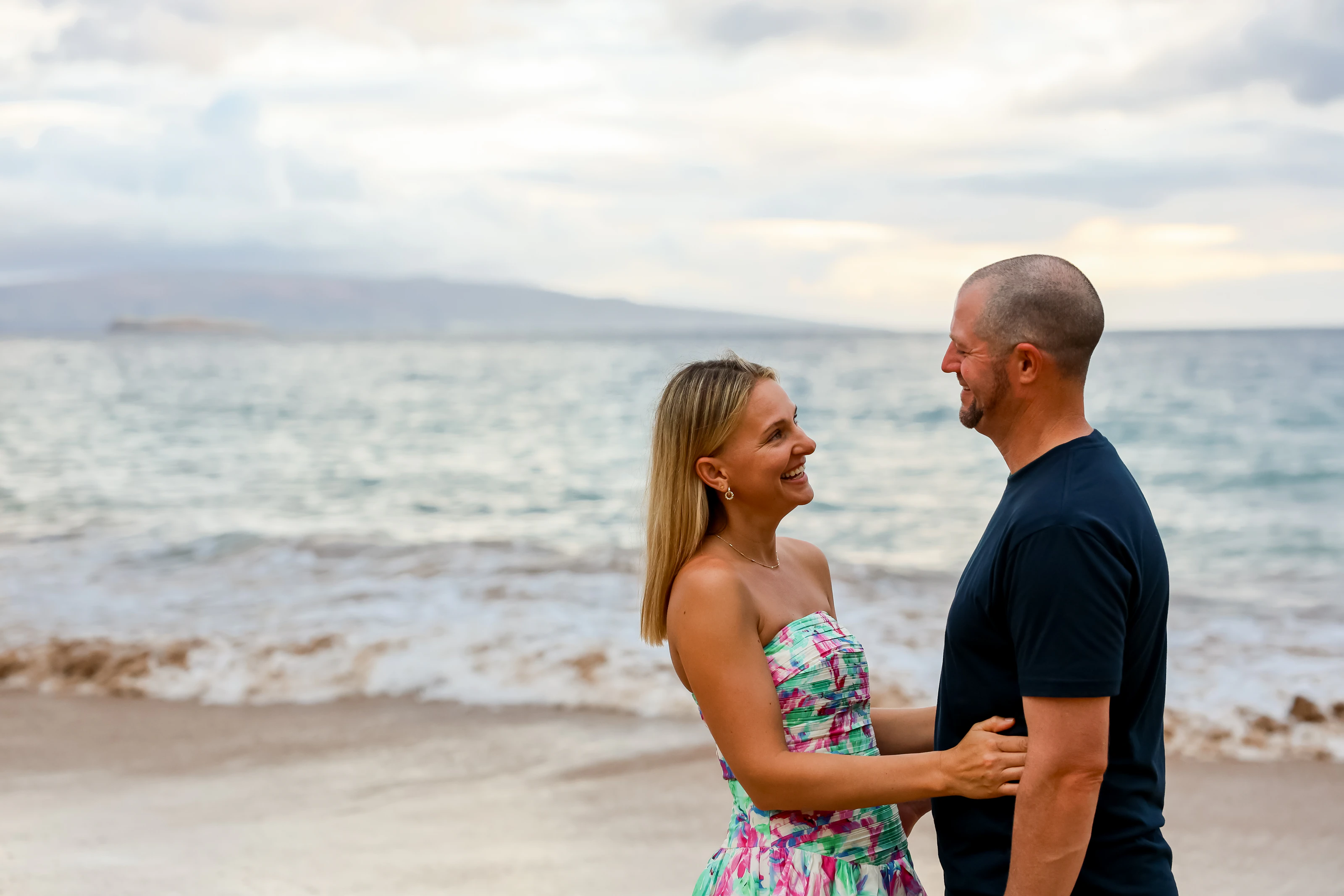 Couple laughing together at the Maui shoreline