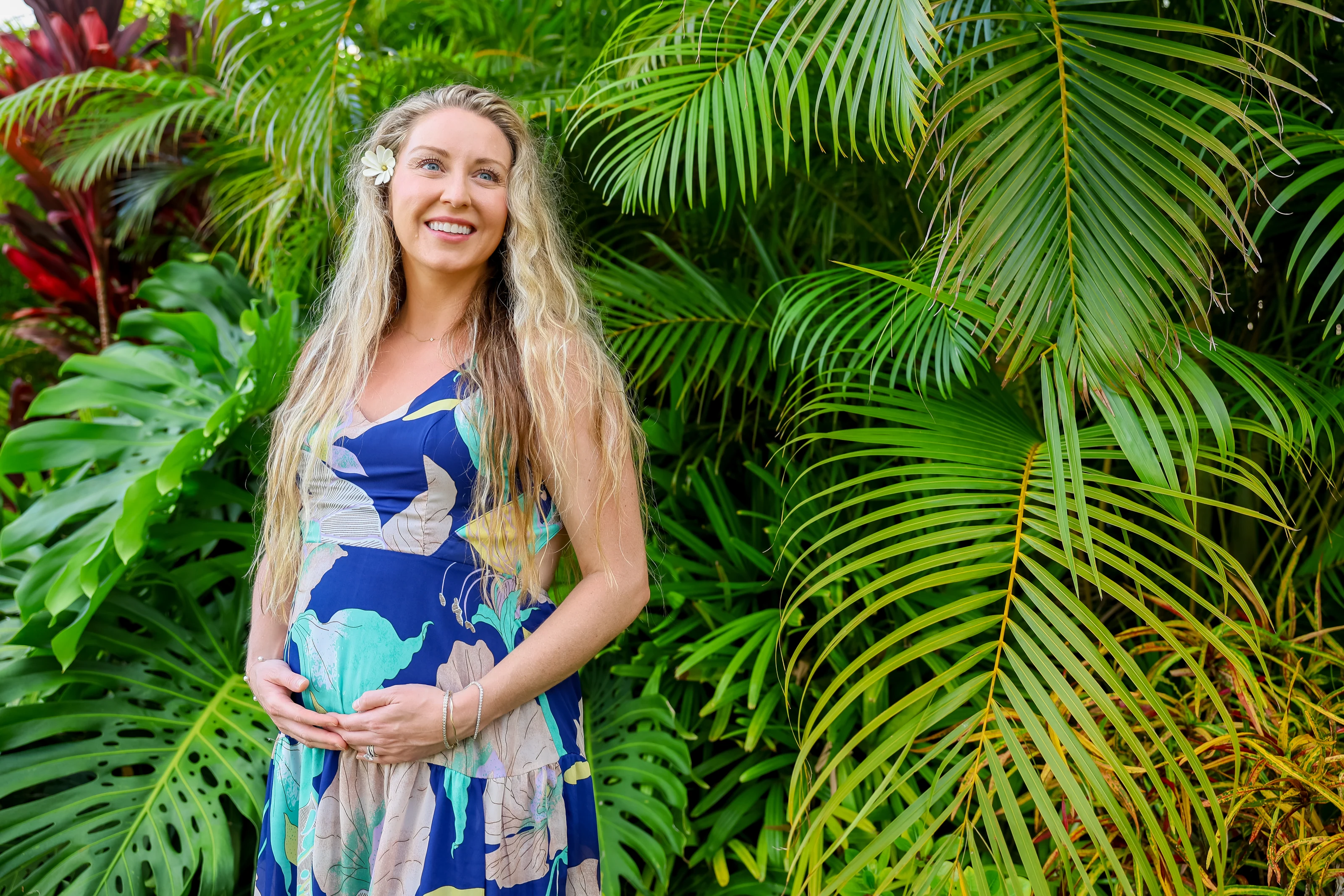 Maternity portrait surrounded by lush tropical palm leaves